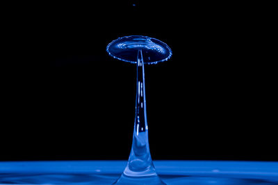 Close-up of water drop on glass against black background