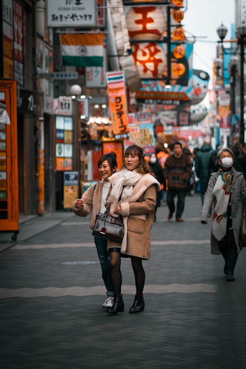 city, architecture, street, building exterior, built structure, city life, real people, full length, people, adult, walking, city street, lifestyles, incidental people, young adult, young men, women, standing, leisure activity, young women, outdoors