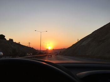 Empty country road against clear sky during sunset