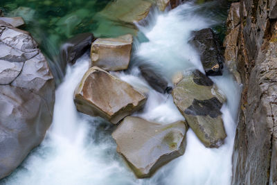 View of stream flowing through rocks