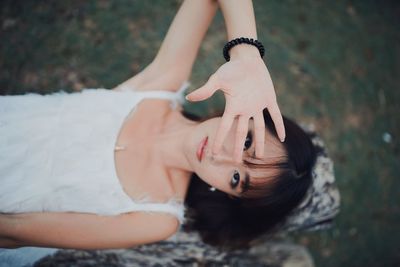 Portrait of young woman lying on wood