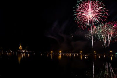 Firework display over river at night