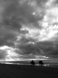 People riding horse on beach