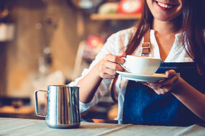 Woman drinking coffee cup on table at cafe