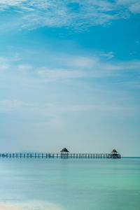 Pier over sea against blue sky