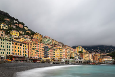 Buildings by sea against sky in city
