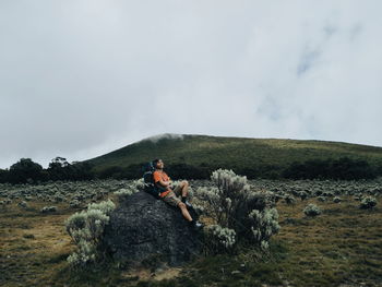 People sitting on mountain against sky