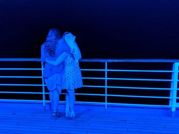 Rear view of woman sitting on staircase at night