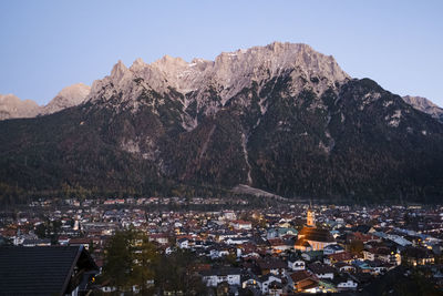 Aerial view of townscape and mountains against clear sky