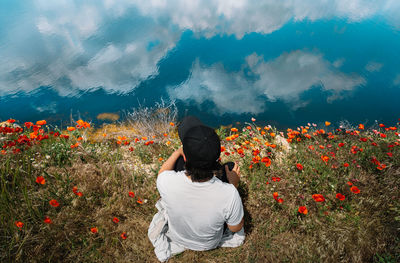 Rear view of woman sitting by plants