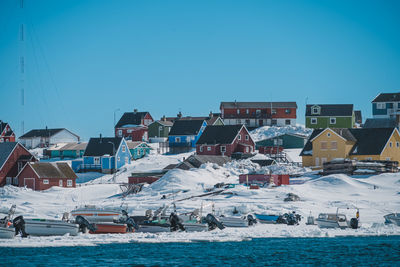 Boats in sea against clear blue sky