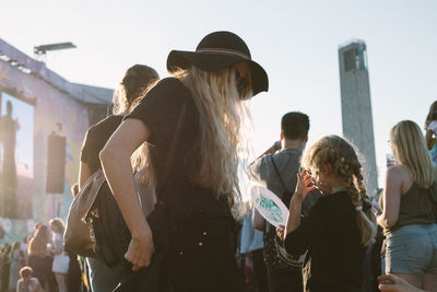 Rear view of people standing against sky