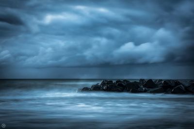 Scenic view of sea against storm clouds