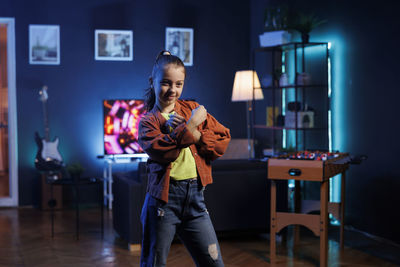 Side view of young woman standing at home