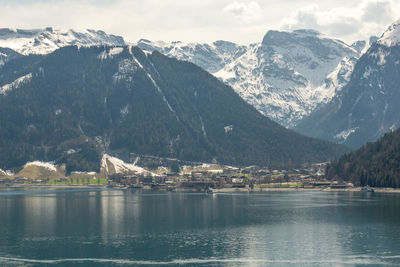 Scenic view of lake by snowcapped mountains against sky