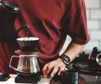 Midsection of man pouring coffee