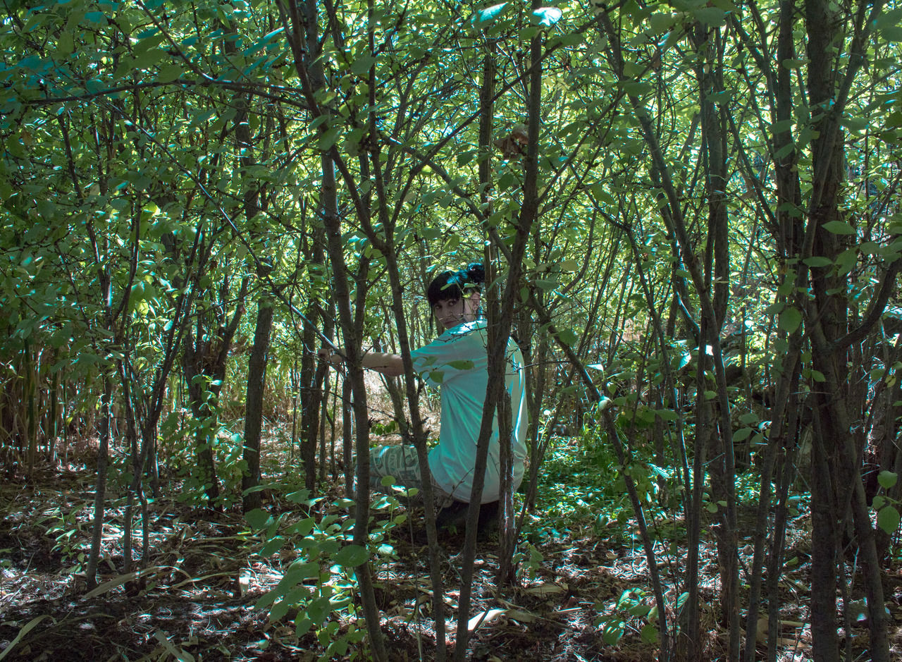 tree, forest, plant, land, one person, woodland, leisure activity, nature, growth, standing, real people, casual clothing, day, young adult, lifestyles, tranquility, full length, beauty in nature, non-urban scene, outdoors