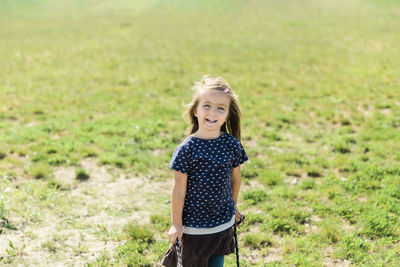 Portrait of smiling girl standing on field