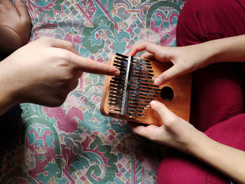 Midsection of mother holding baby playing