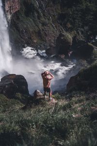 Man standing next to waterfall 