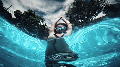 Low angle view of young woman swimming in pool