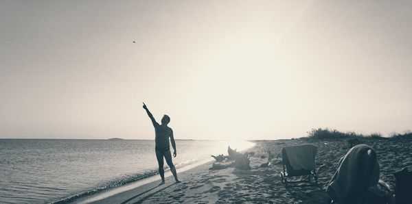 Full length of person on beach against clear sky