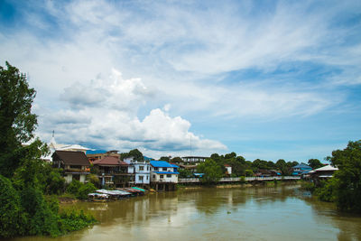 Houses by trees against sky