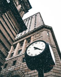 Low angle view of clock tower against sky in city