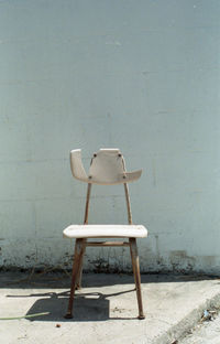 Empty chair against wall