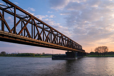 Old bridge crossing the rhine river, sunset at rhinepark, duisburg, germany