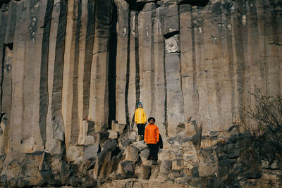 Rear view of men standing on rock