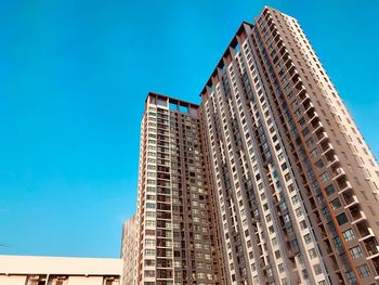 Low angle view of modern building against blue sky