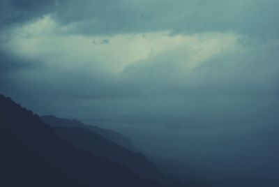 Scenic view of mountains against cloudy sky