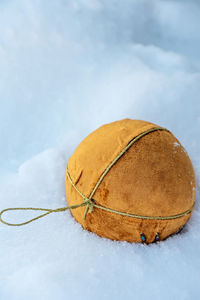 Orange christmas ball on the snow with copy space