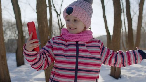 Portrait of smiling girl standing in snow