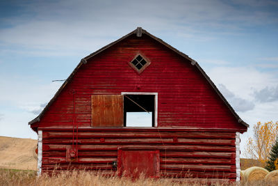 Exterior of old house on field against sky