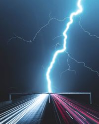 Panoramic view of lightning over road