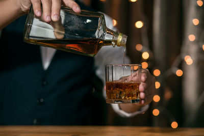 Midsection of person holding wine glass