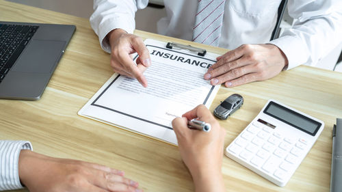 Midsection of businessman working on table