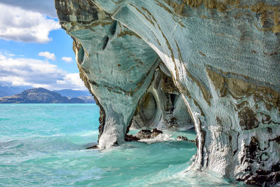 Scenic view of rock formation in sea against sky