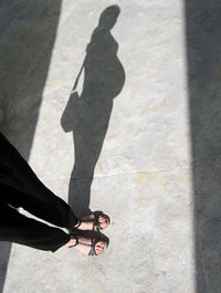 Low section of woman standing on concrete floor