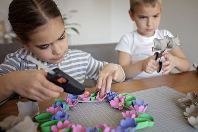 Kids create easter flower wreath in pastel colors using an upcycled egg trail. zero waste lifestyle