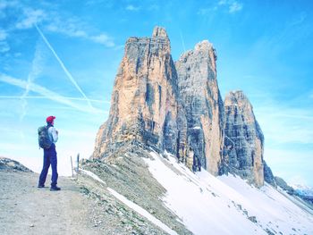 Traveler man enjoying serene view tre cime mountains and landscape. travel lifestyle hiking concept 