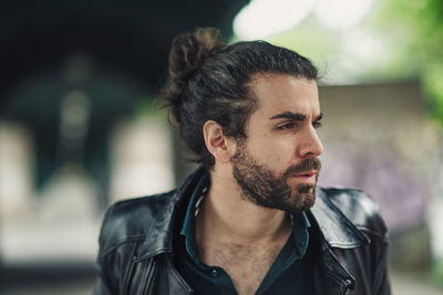 Portrait of young man looking away outdoors