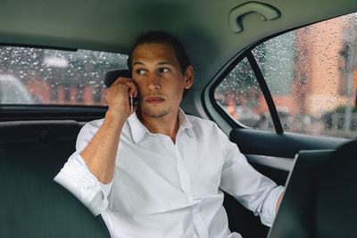 Businessman talking over smart phone in car