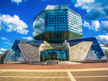 Low angle view of modern building against cloudy sky