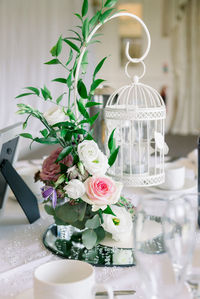 Close-up of white roses in glass vase on table
