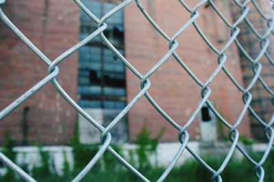 Close-up of chainlink fence against building