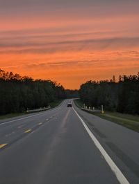 Empty road against sky during sunset