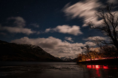 Scenic view of lake against sky at night
